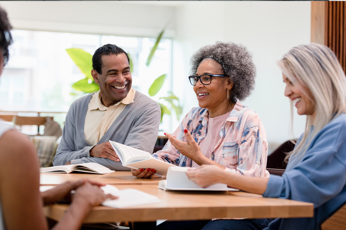 a few elderly people attend a book club and smile